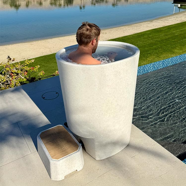 Vertical tub with a small step on a stone patio