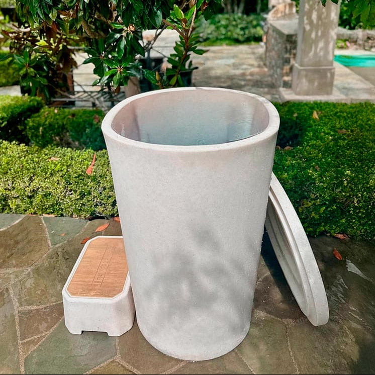 Vertical tub with a small step on a stone patio