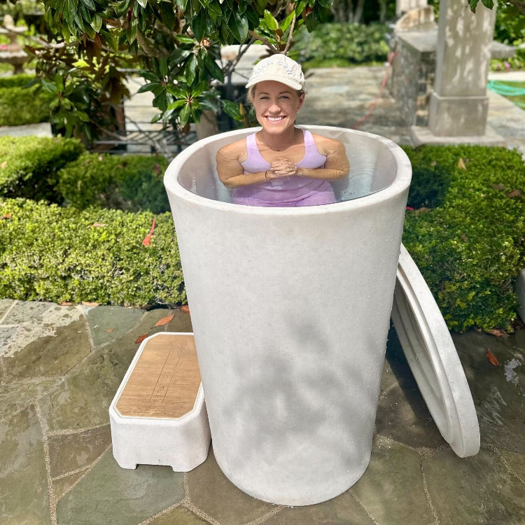 A woman in a vertical tub with small step in a garden 